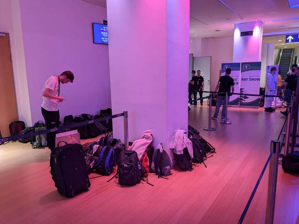 Photo of a bunch of backpacks leaning against a pillar in the hall leading to the Dealer’s Den