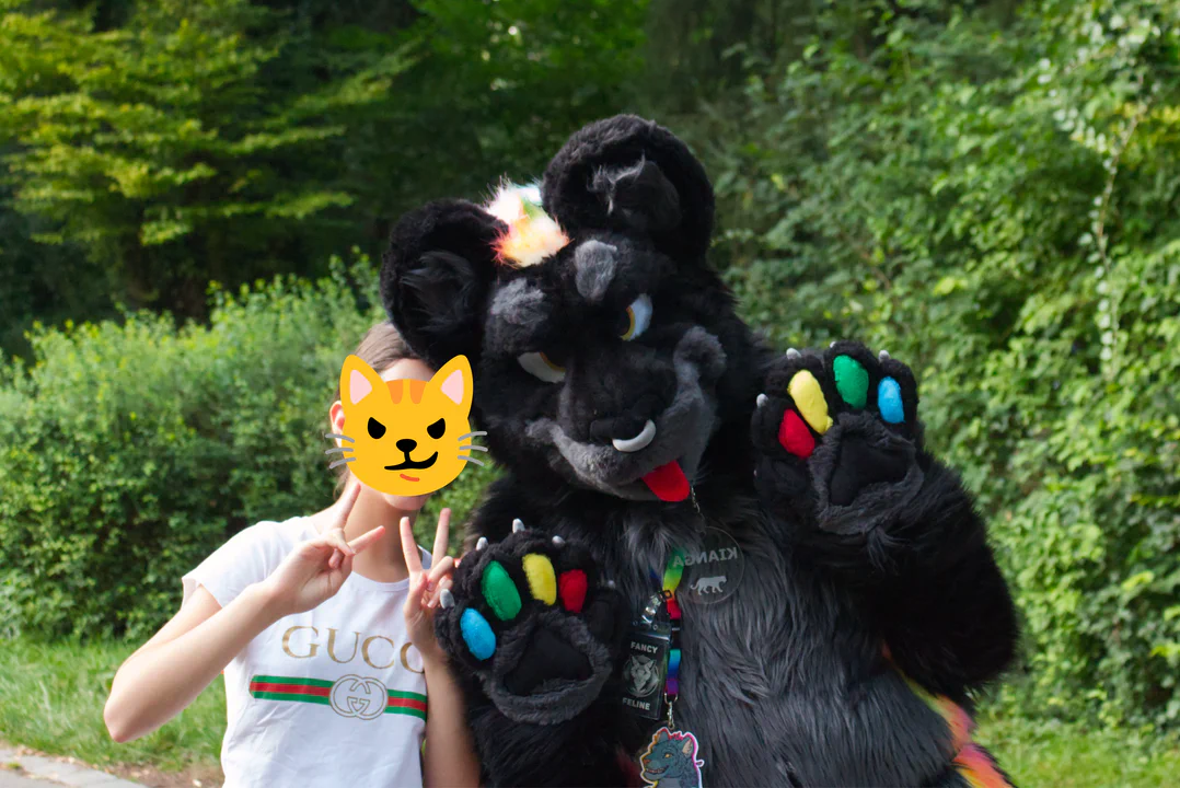 A black jaguar fursuiter standing next to a child making peace signs